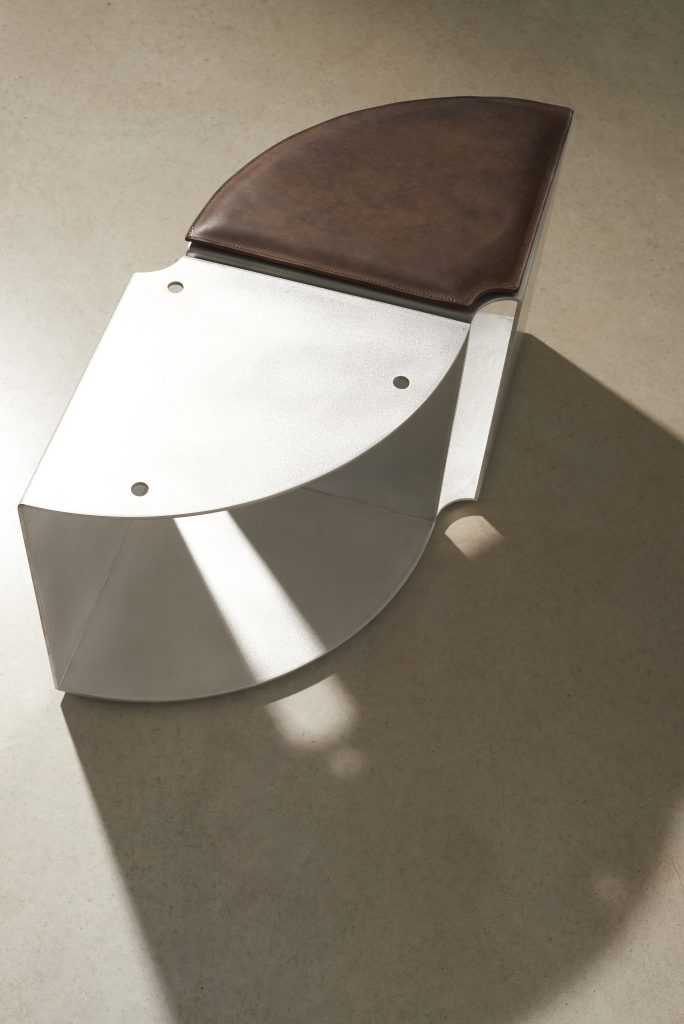 PARELLO brown leather cushion resting on a satin aluminium Lello quarter-circle module